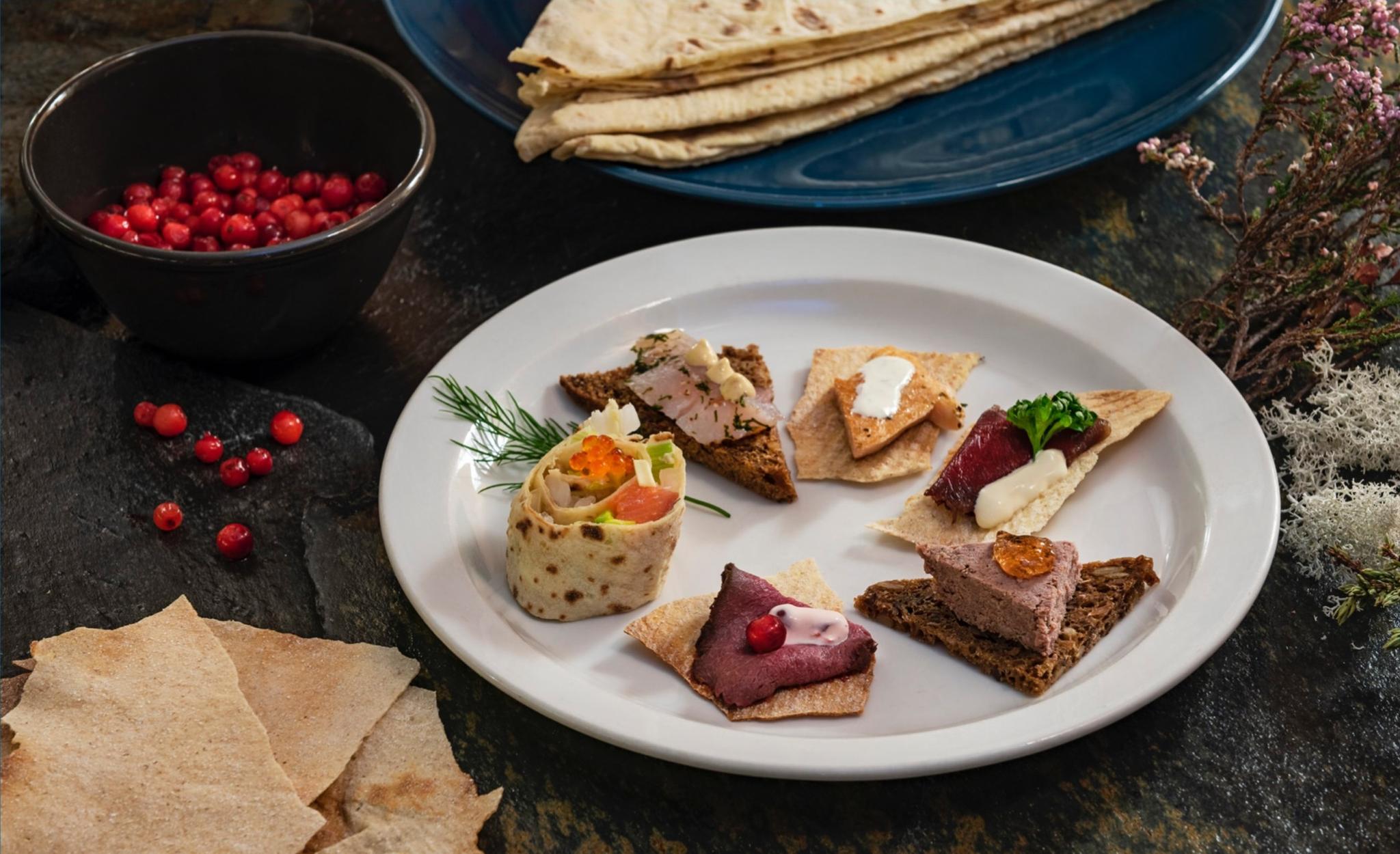 A tasting plate with five pates on toast and a lease roll 