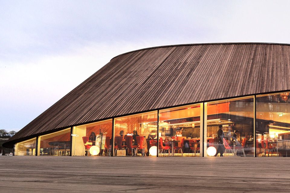 Exterior of brown restaurant with big windows.