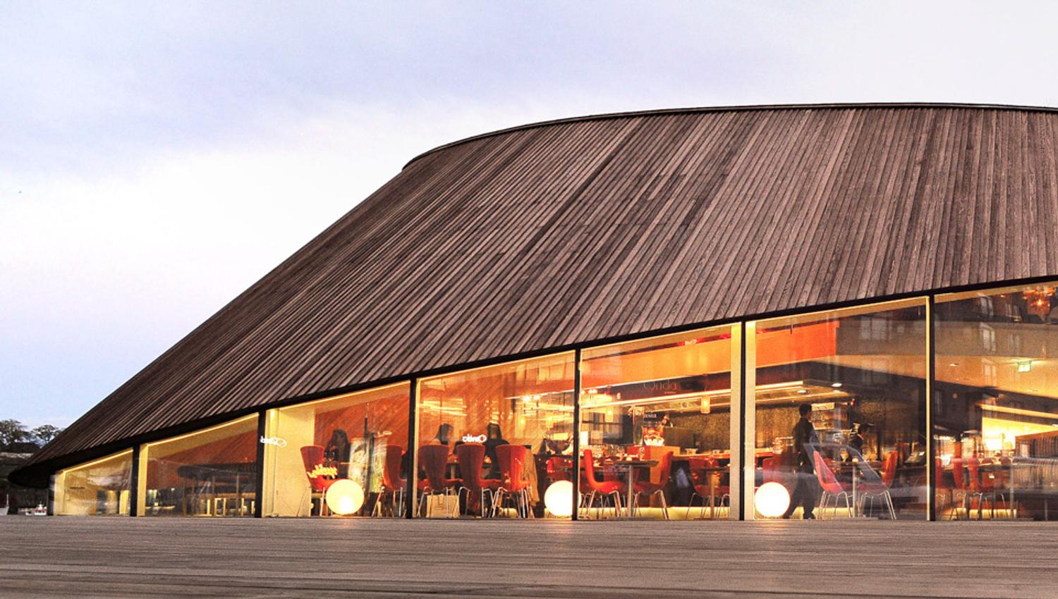 Exterior of brown restaurant with big windows.