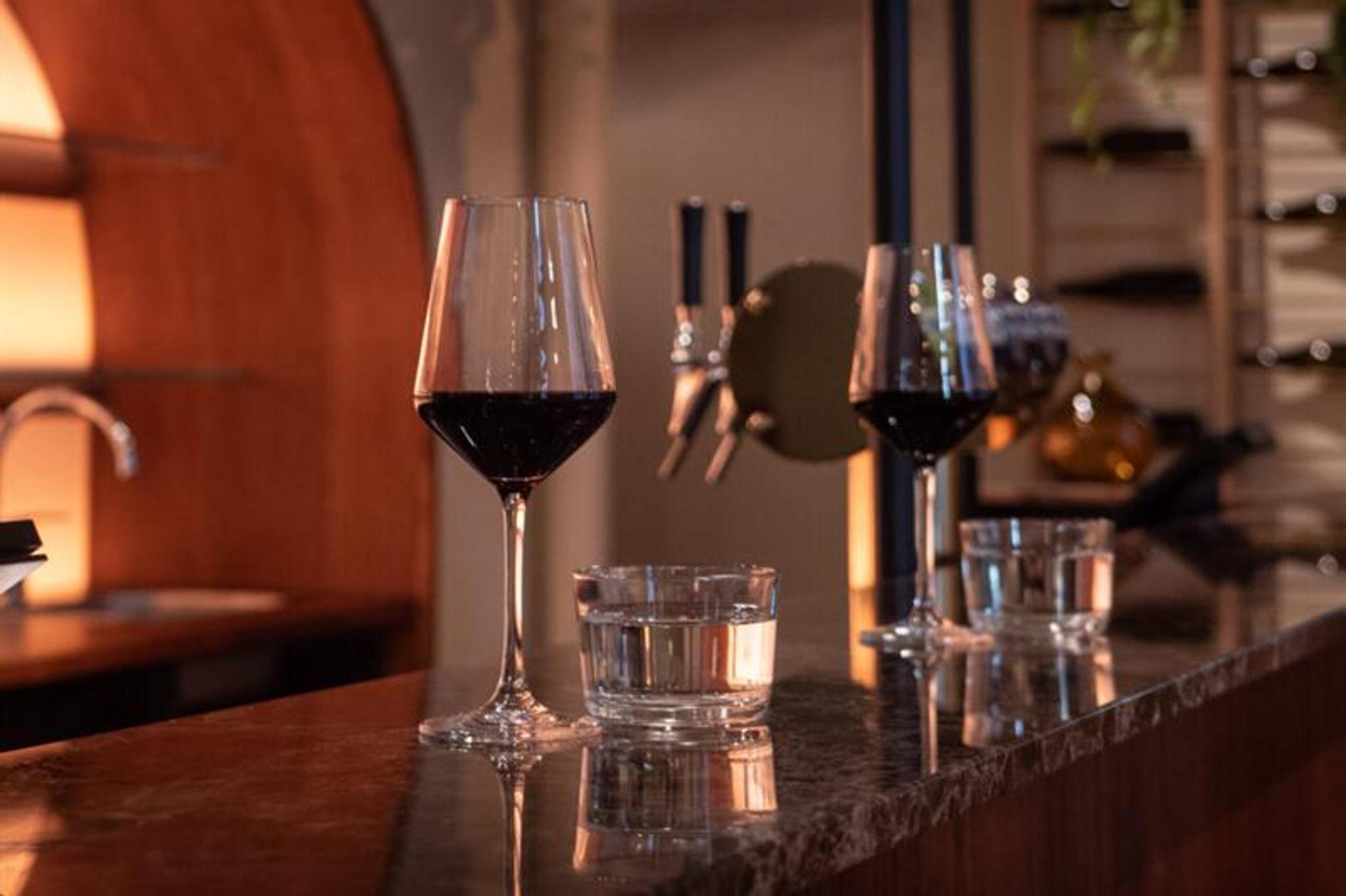 Two glasses of red wine on the counter.