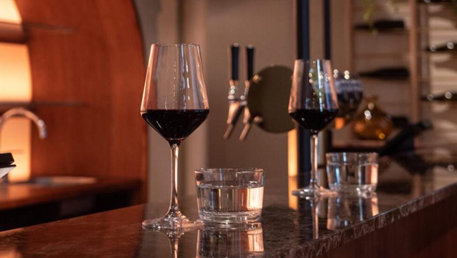 Two glasses of red wine on the counter.
