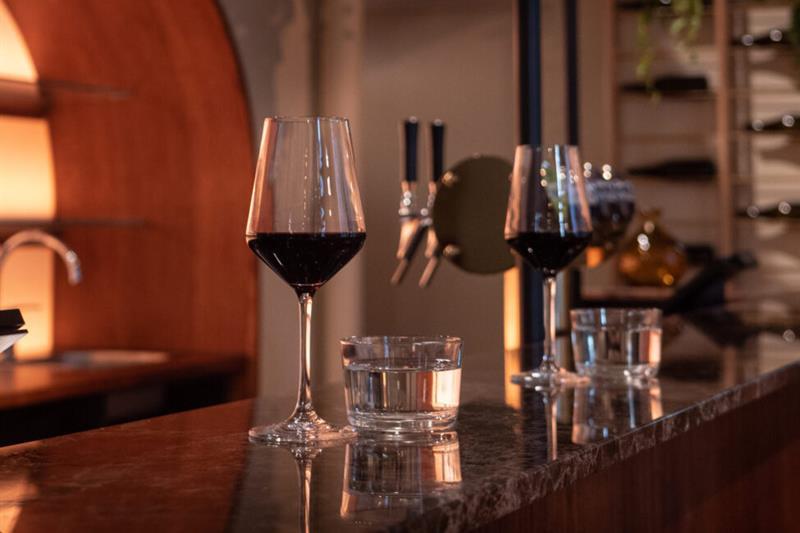 Two glasses of red wine on the counter.