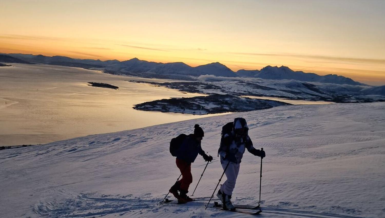 To gjester følger skisporene, men fjorden reflekterer ettermiddagslyset