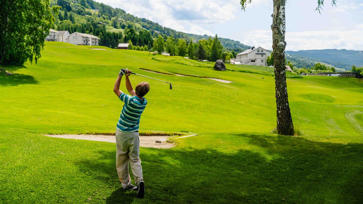 Golfer hitting a shot on the golf course.