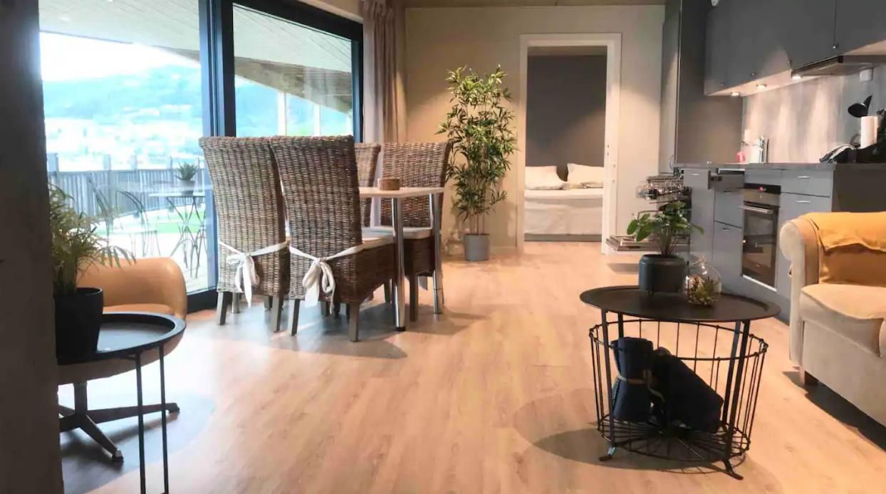 Spacious living room with natural materials and modern interior, overlooking the fjord.