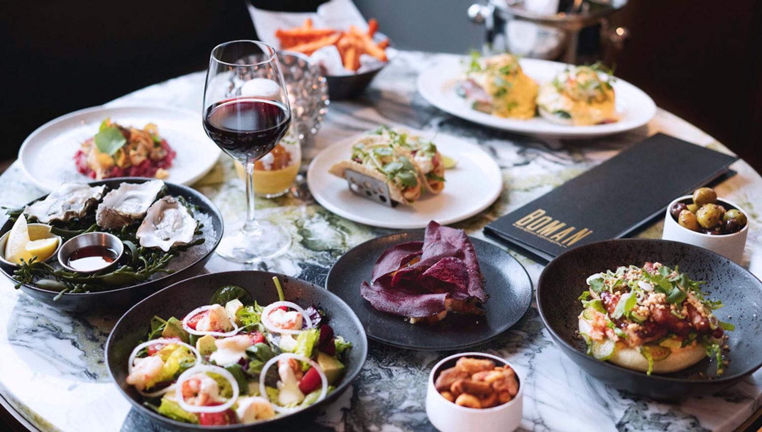 Table set with different dishes and a glass of red wine