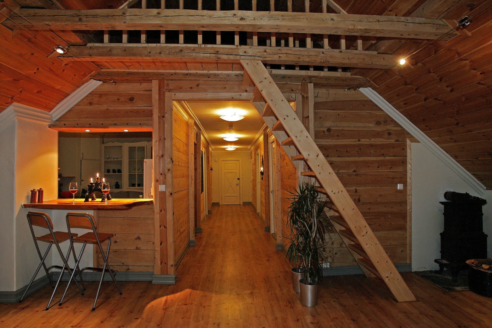 Bright and cozy common area at Vikinghaug Apartments featuring wooden interiors, a small bar and open staircase, perfect for relaxed evenings.