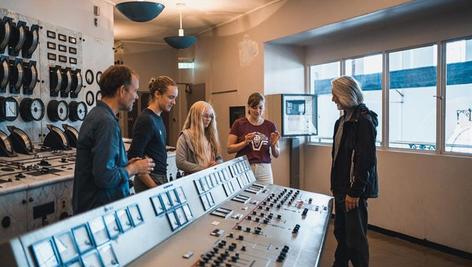 A group of visitors inside the control room at the Kraftmuseet, learning about Norway's energy history.