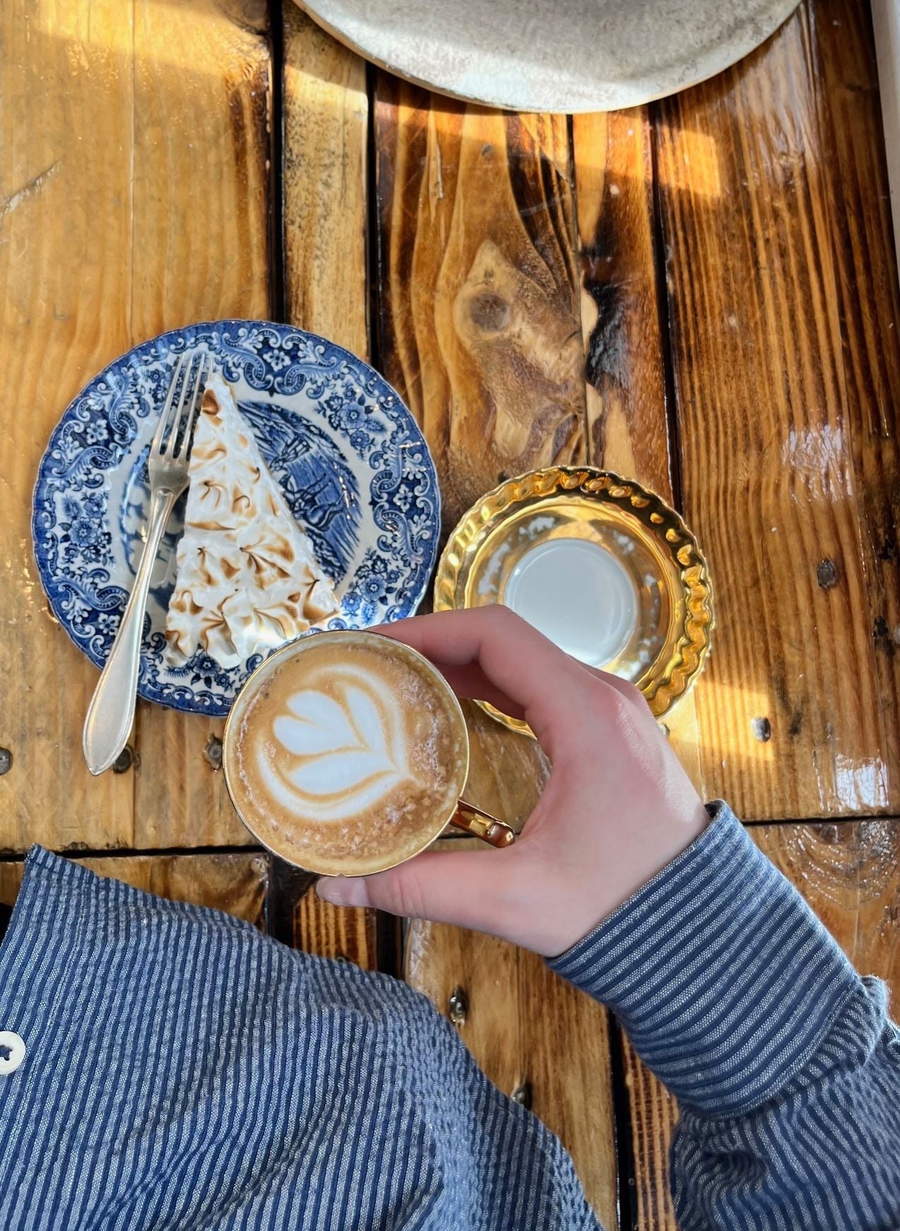 Kaffekopp med latte art og kake på et trebord