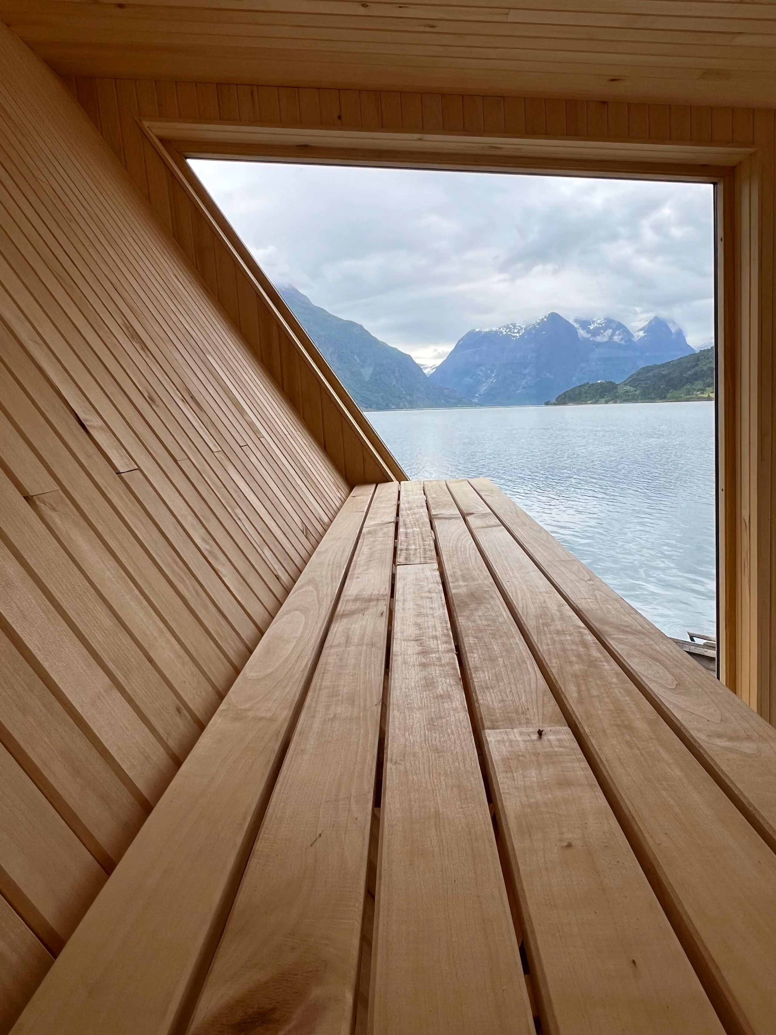 Frå benkane i Lidasanden Floating Sauna får du panoramautsikt over Oppstrynsvatnet og fjella rundt.
