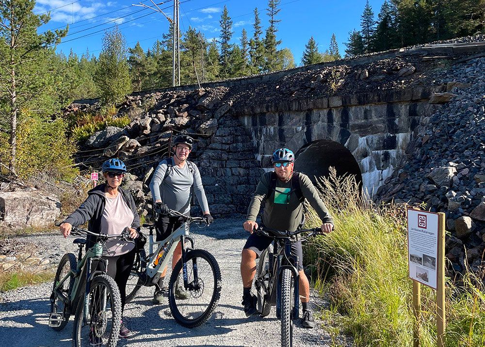 3 cyclists in front of a bridge on the cycle path "culture round" in Drangedal 