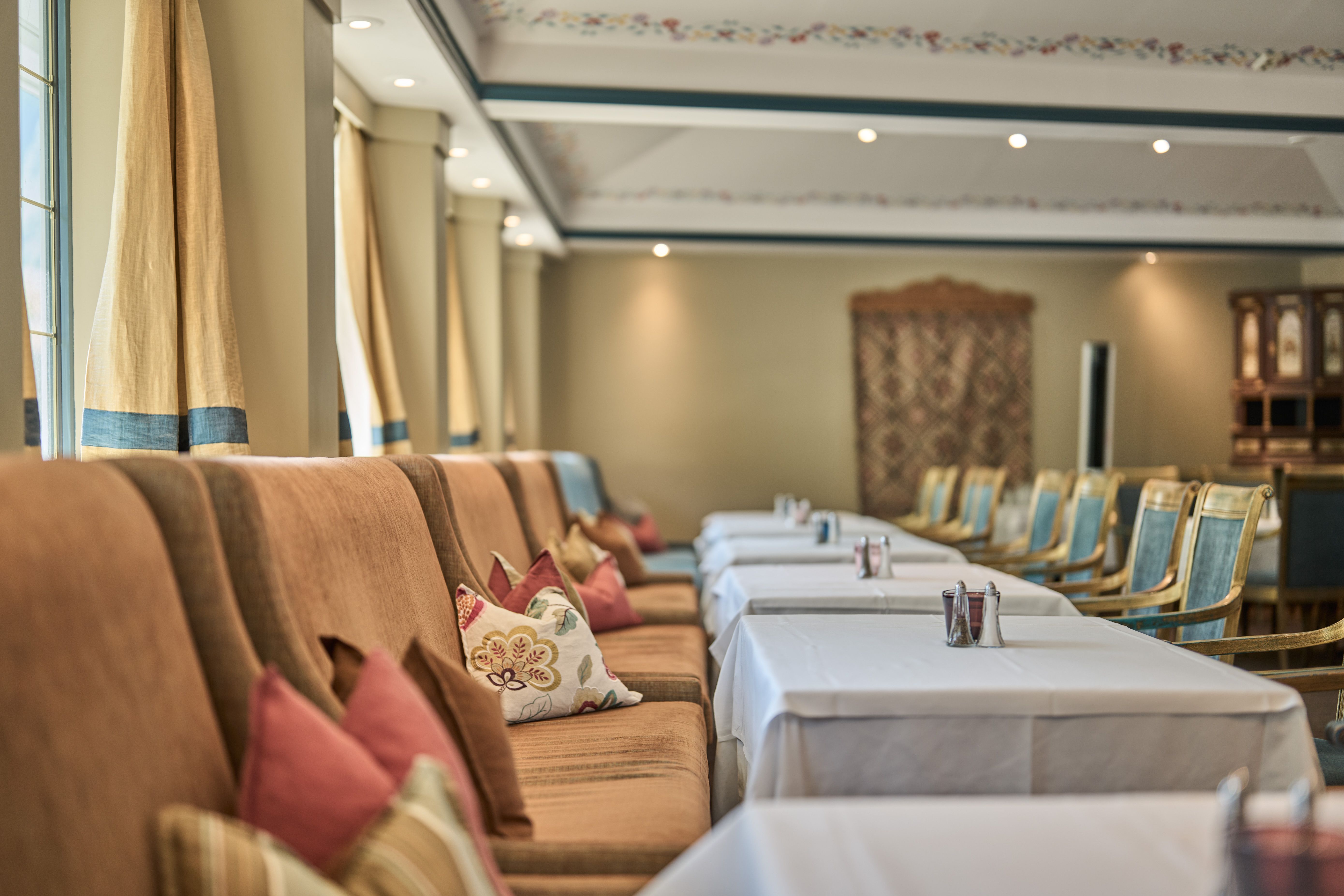 Elegant dining room with decorated chairs and pillows at Hotel Ullensvang.