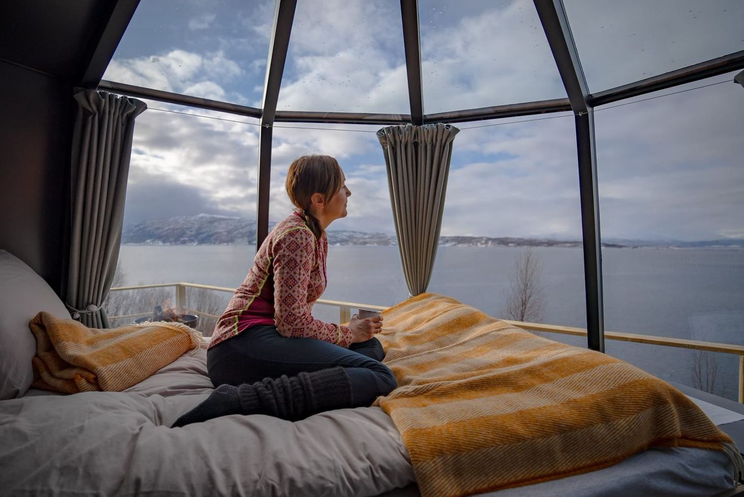 Guest sitting inside little hut and looking out at the sea