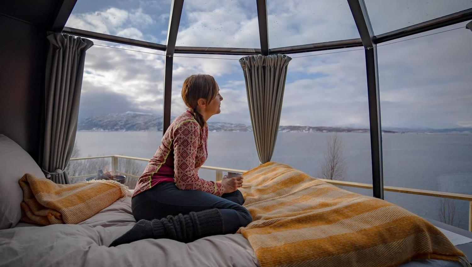 Guest sitting inside little hut and looking out at the sea