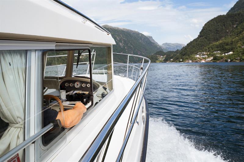 The captain of Pilagutt enjoys the view as the boat cruises through the Hardangerfjord – a relaxing and scenic journey.