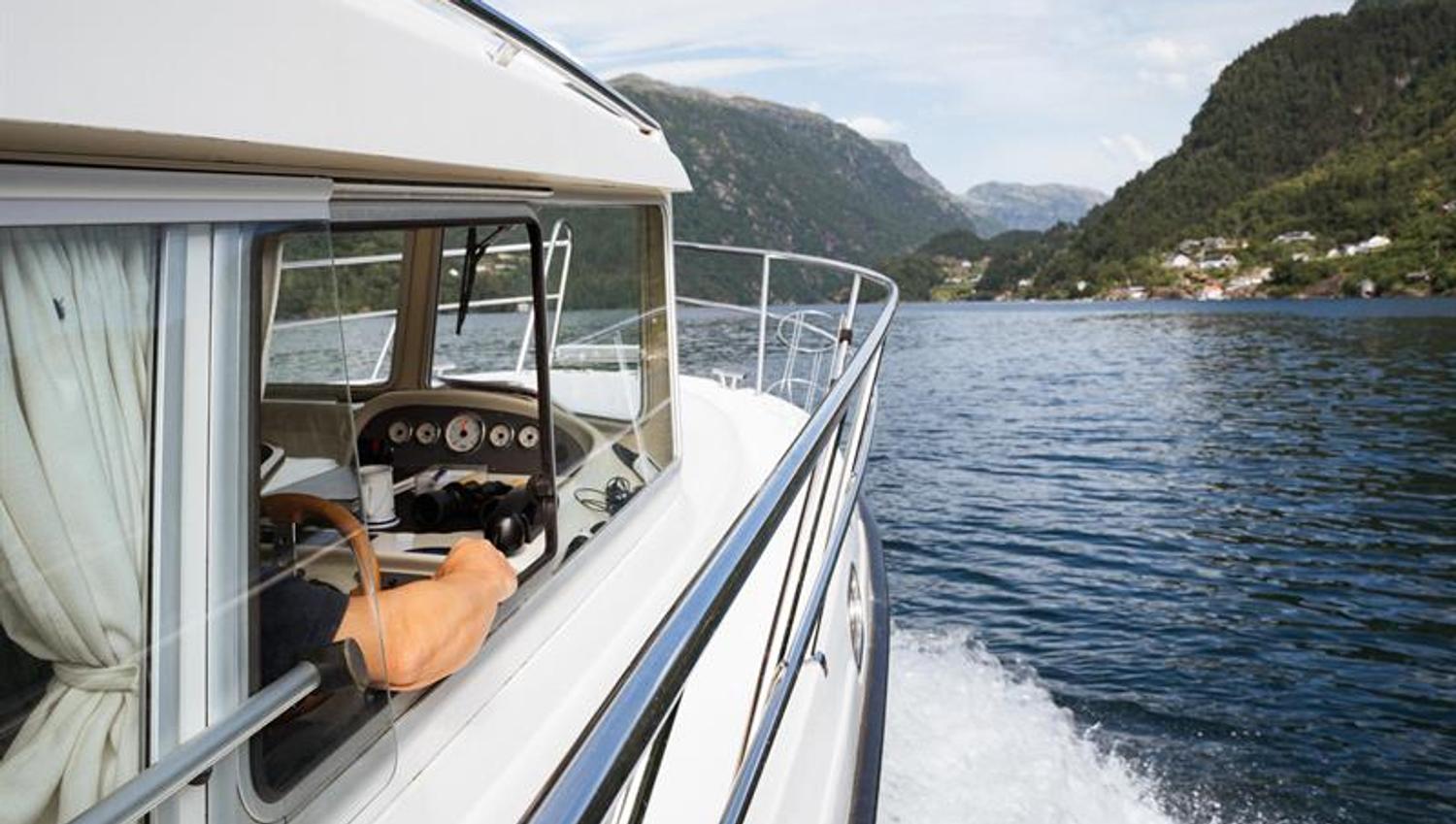The captain of Pilagutt enjoys the view as the boat cruises through the Hardangerfjord – a relaxing and scenic journey.