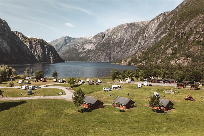 Sæbø camping seen from the main road, with the lake and mountains in the background.
