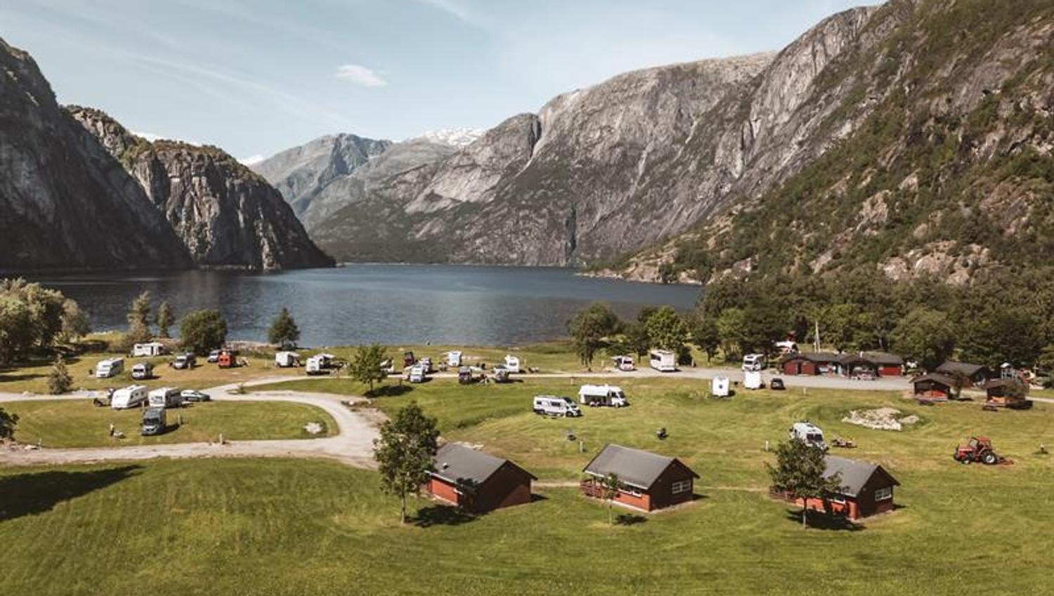 Sæbø camping seen from the main road, with the lake and mountains in the background.