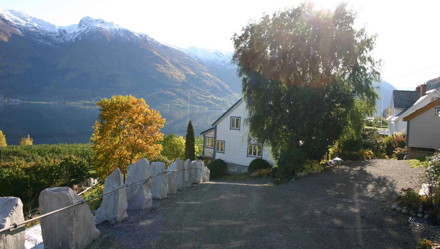 Driveway at Hardanger Harmoni Fjordhus with panoramic fjord and mountain view.