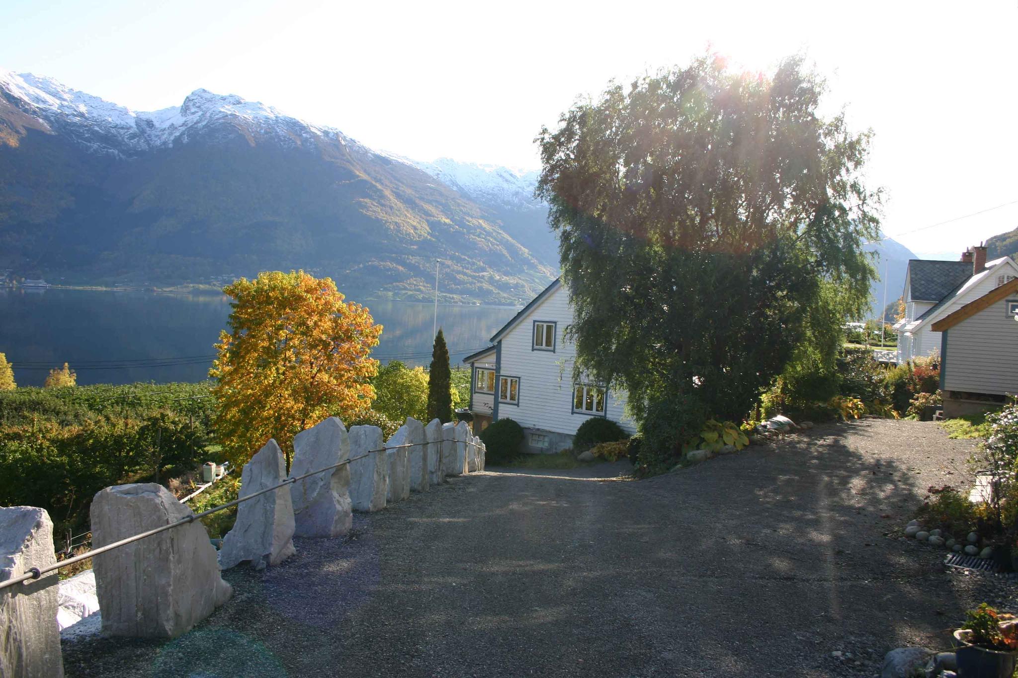 Driveway at Hardanger Harmoni Fjordhus with panoramic fjord and mountain view.