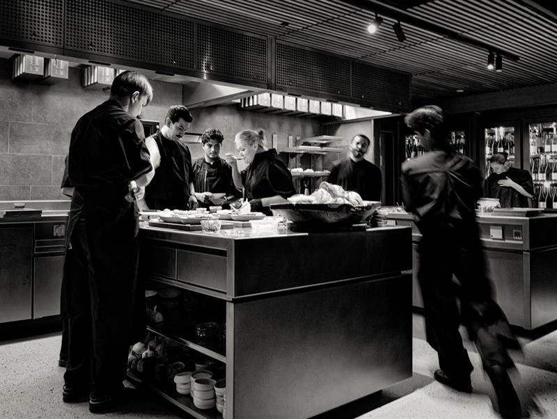 Black and white photo from the kitchen, with chefs working