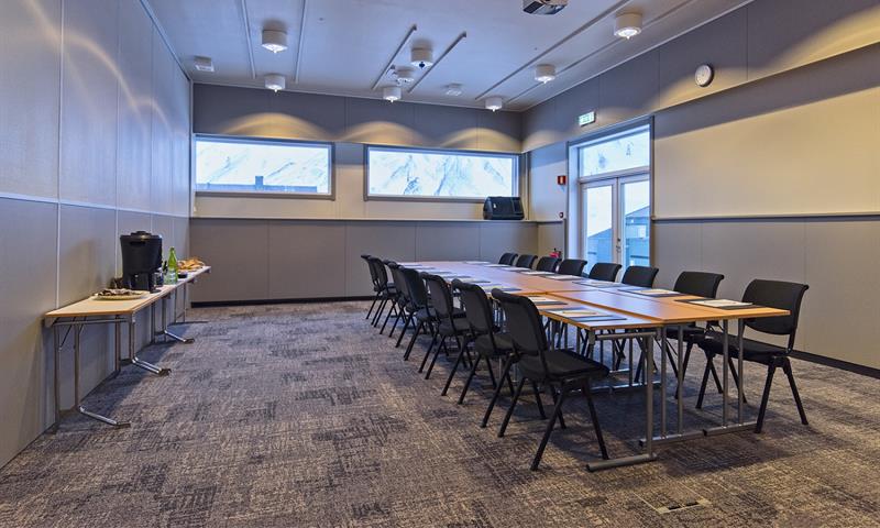 A conference room with a long table, chairs and refreshments