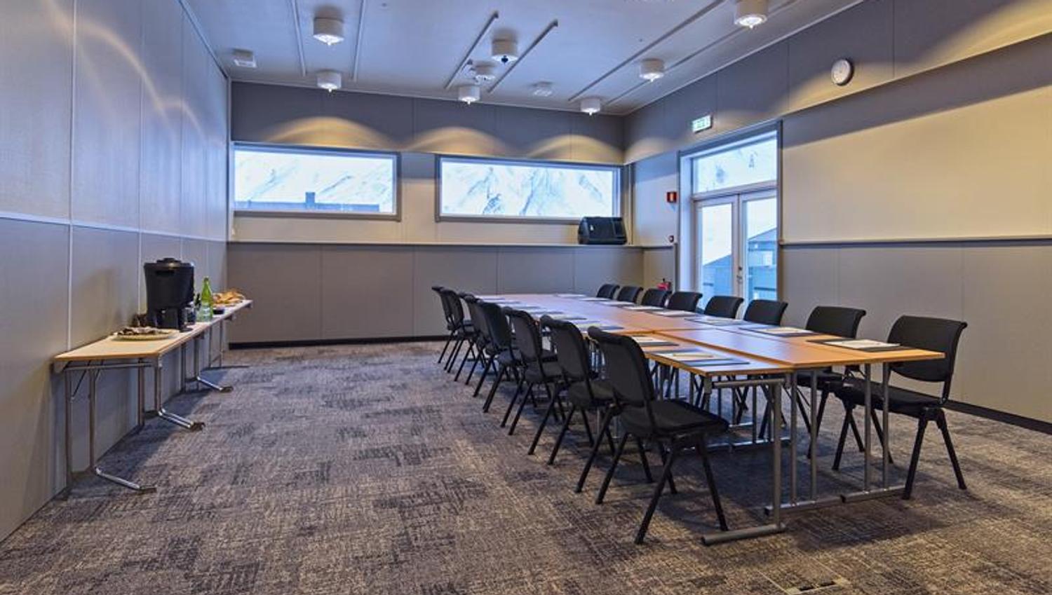 A conference room with a long table, chairs and refreshments