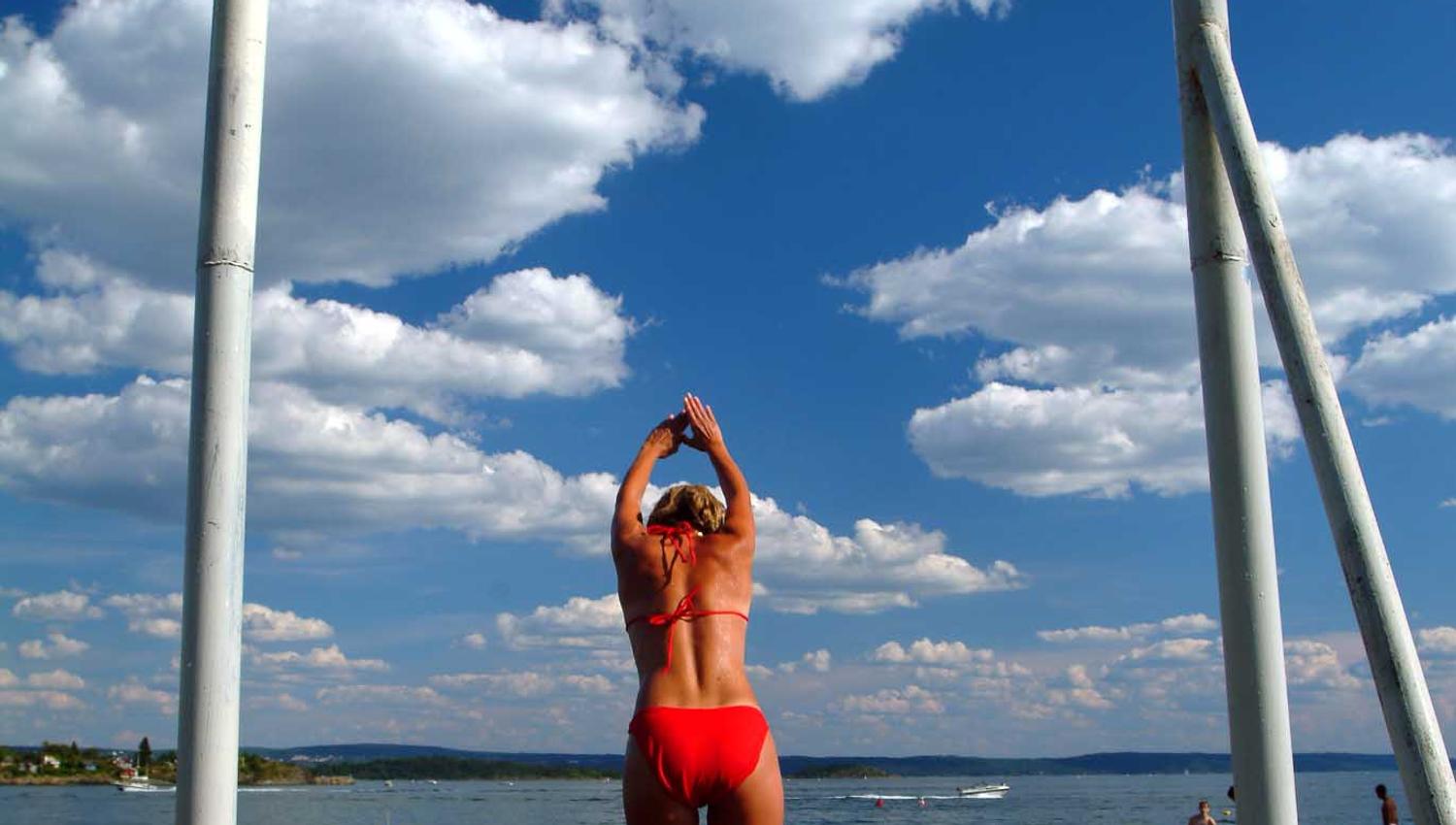 Girl jumping from a pier