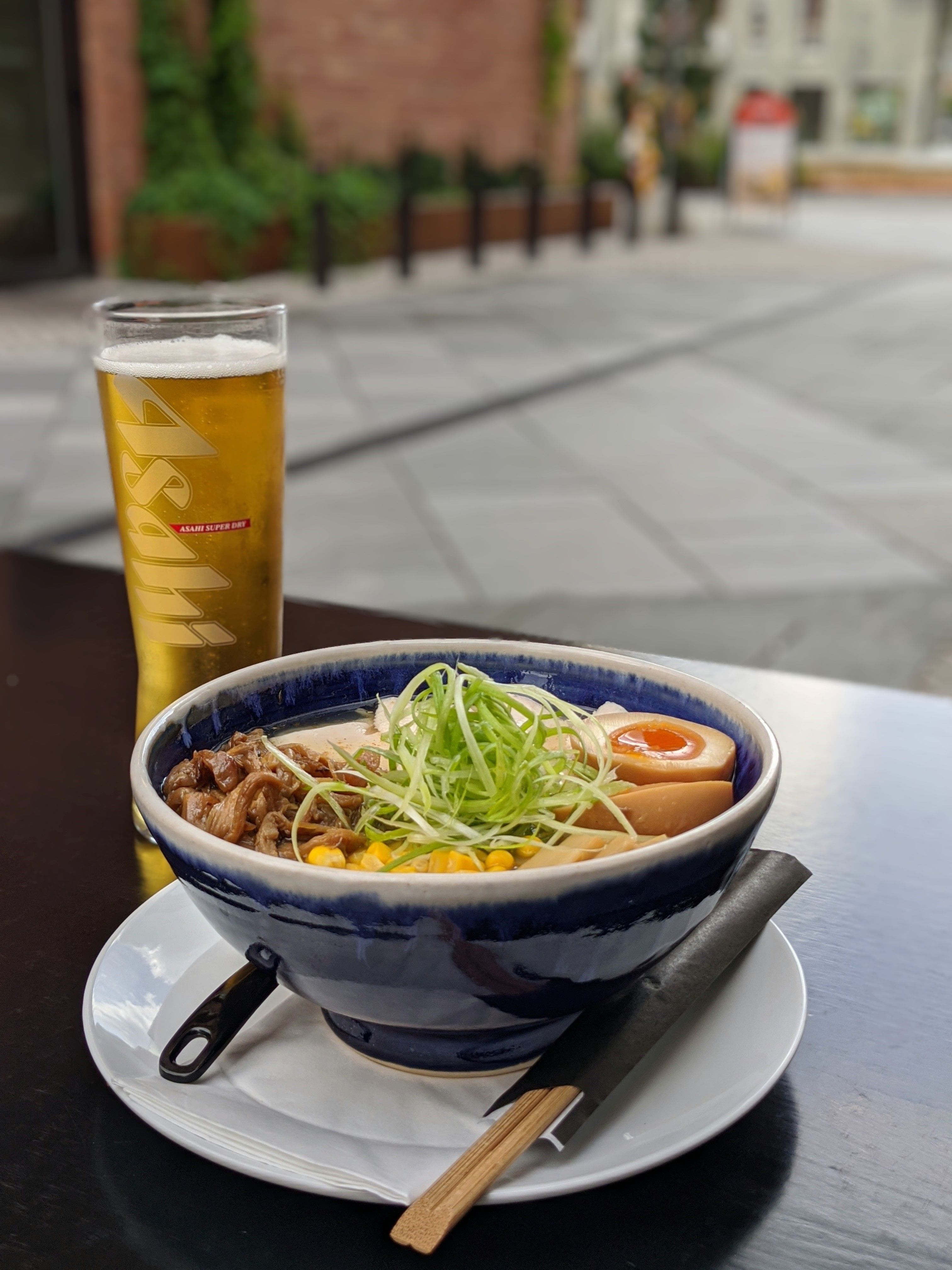Detaljbilde av ramen i en blå bolle ved siden av et glass øl.