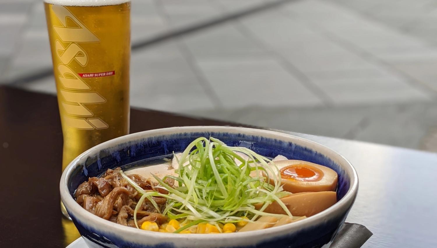 Detaljbilde av ramen i en blå bolle ved siden av et glass øl.