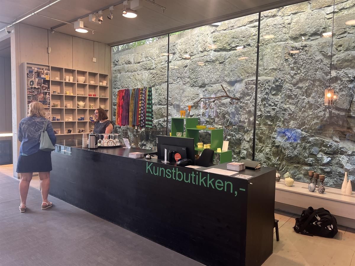 Reception area in the art shop with a counter, glass wall, and displayed items.