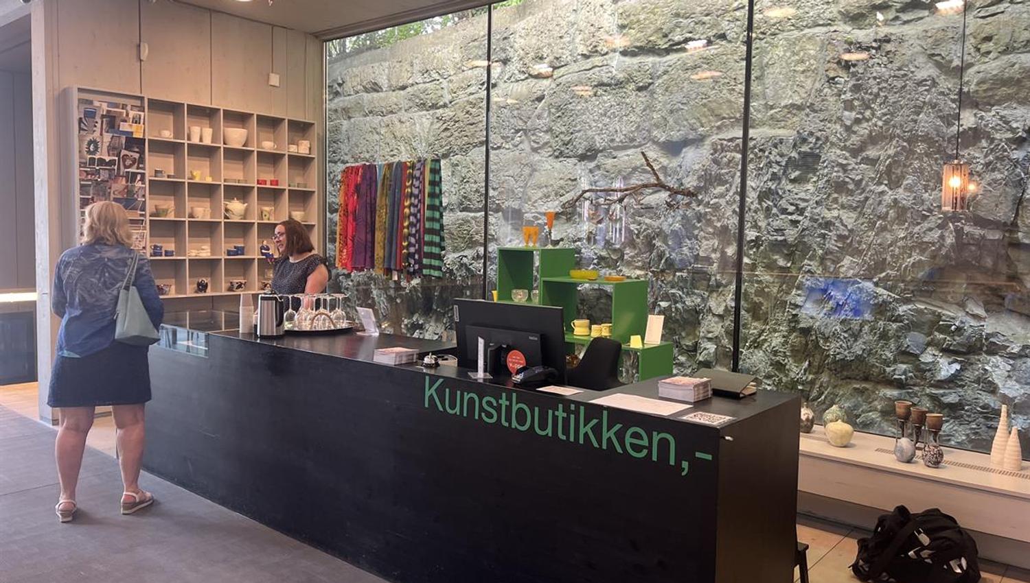 Reception area in the art shop with a counter, glass wall, and displayed items.