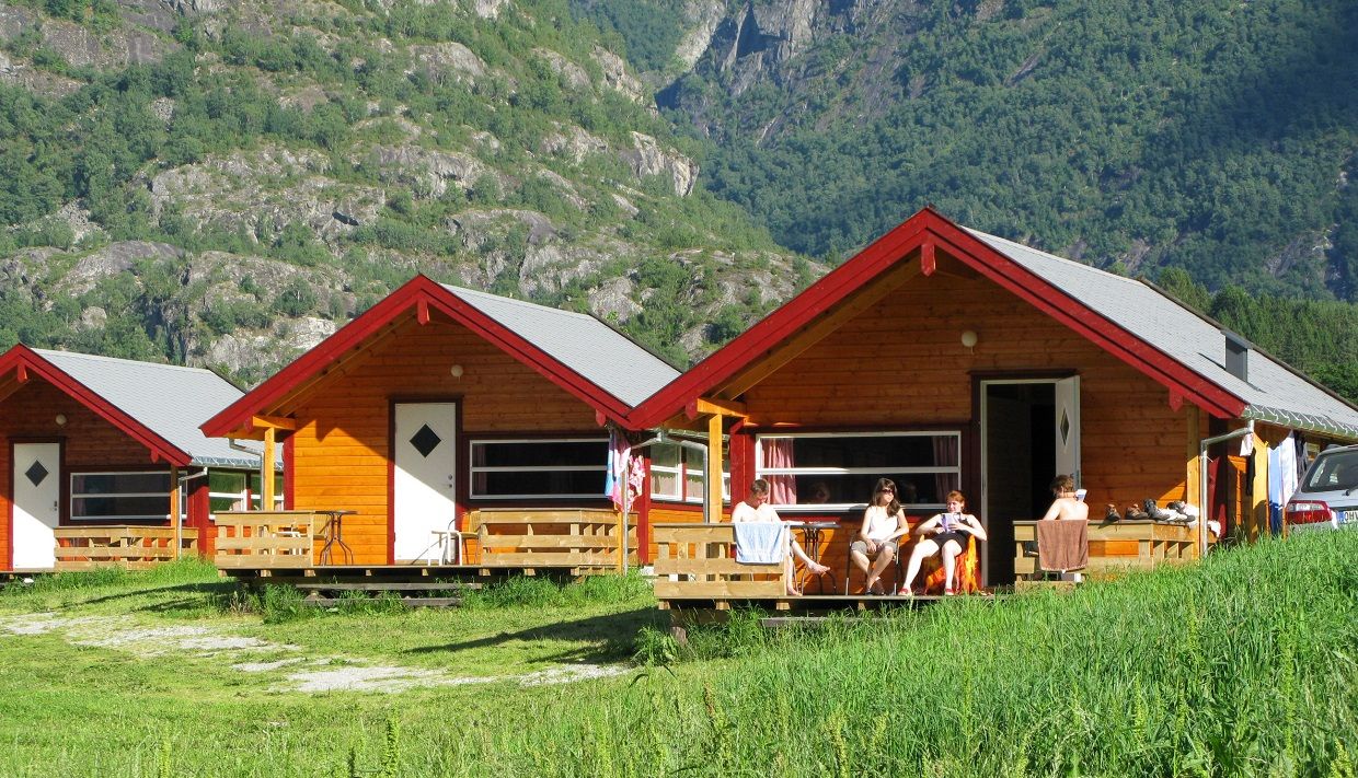 Three of the cabins at the campground, with people lounging on one of the patios.