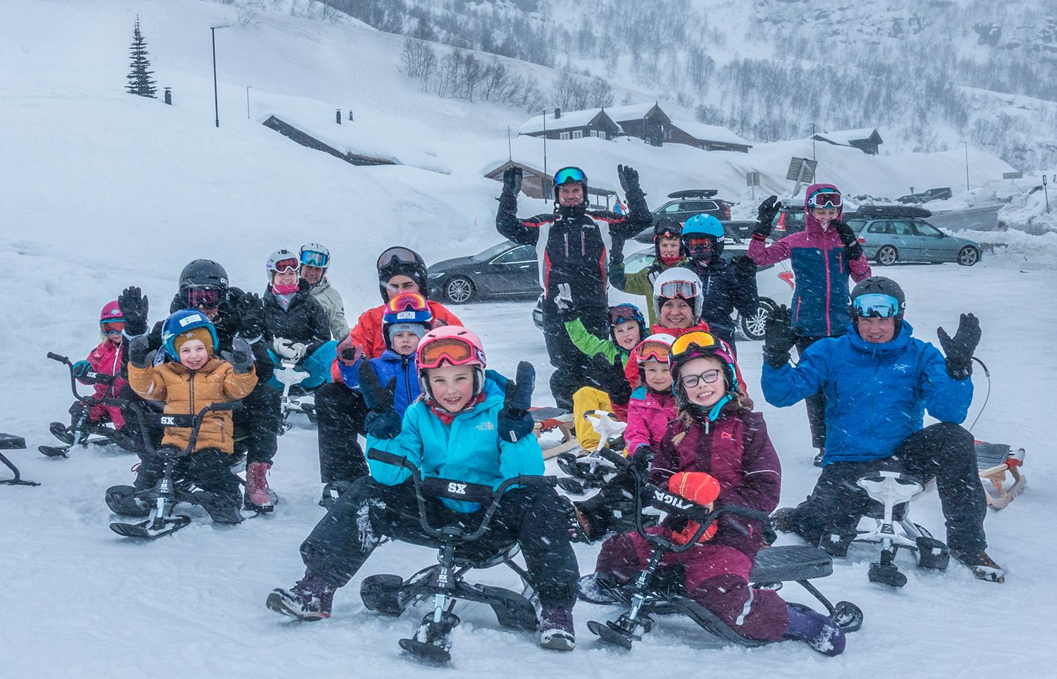 A group of happy kids on sleds. 