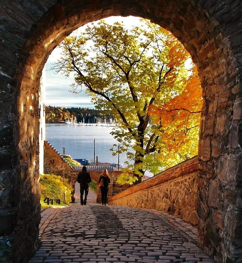 Autumn photo of two people walking alongside the fortress.