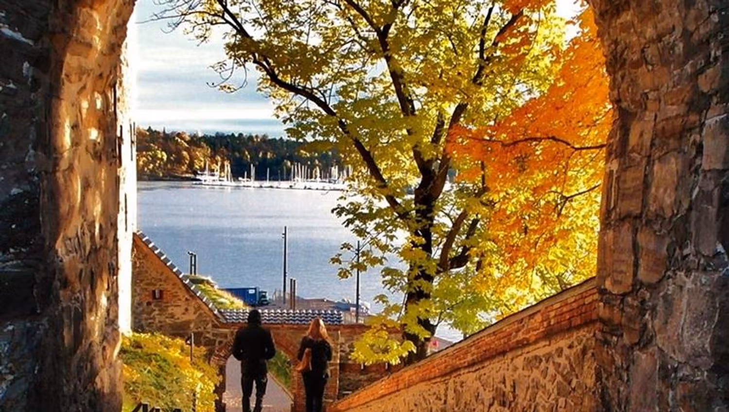 Autumn photo of two people walking alongside the fortress.