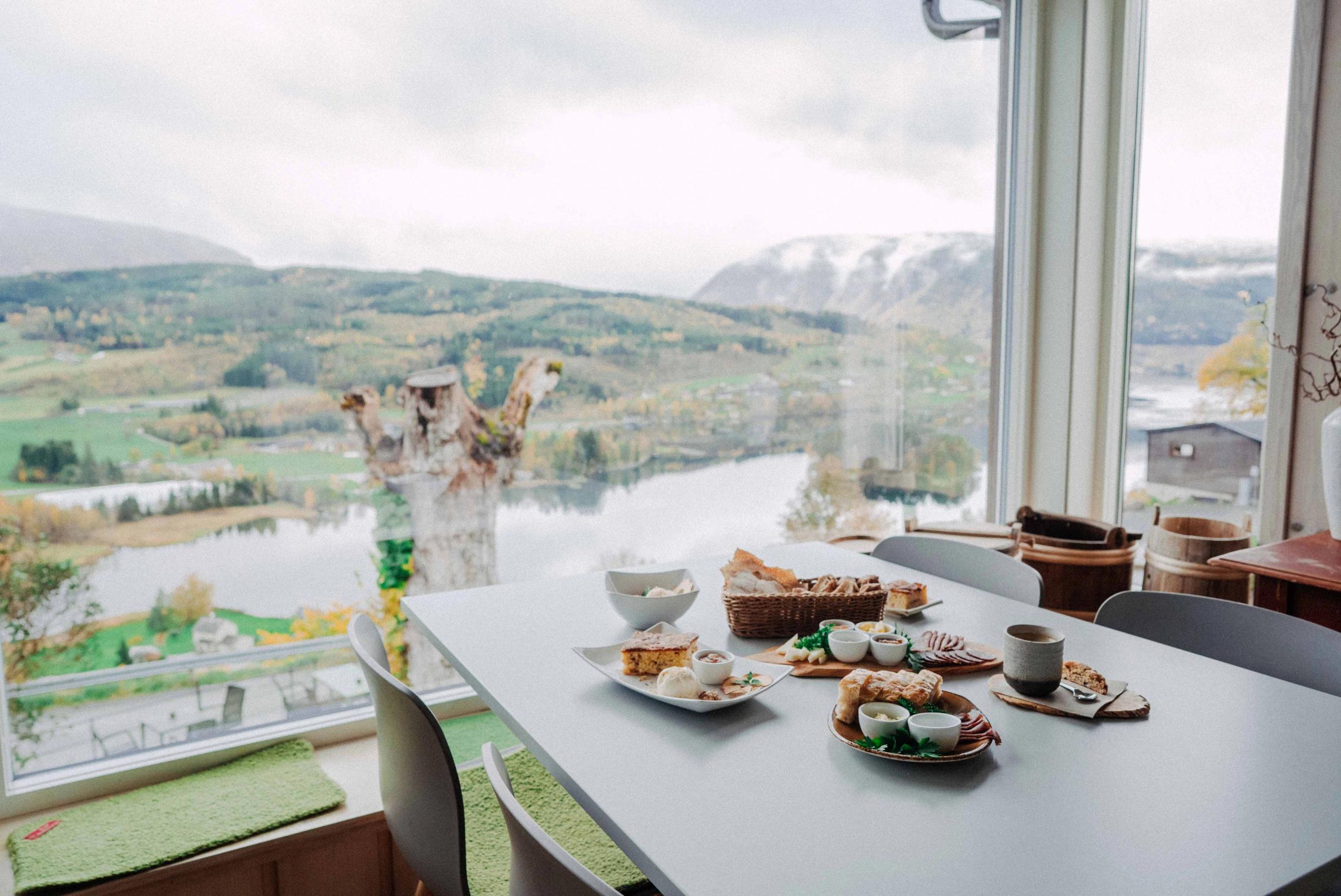 Eit bord fylt med lokal mat frå Hardanger med panoramautsikt over fjordlandskapet.
