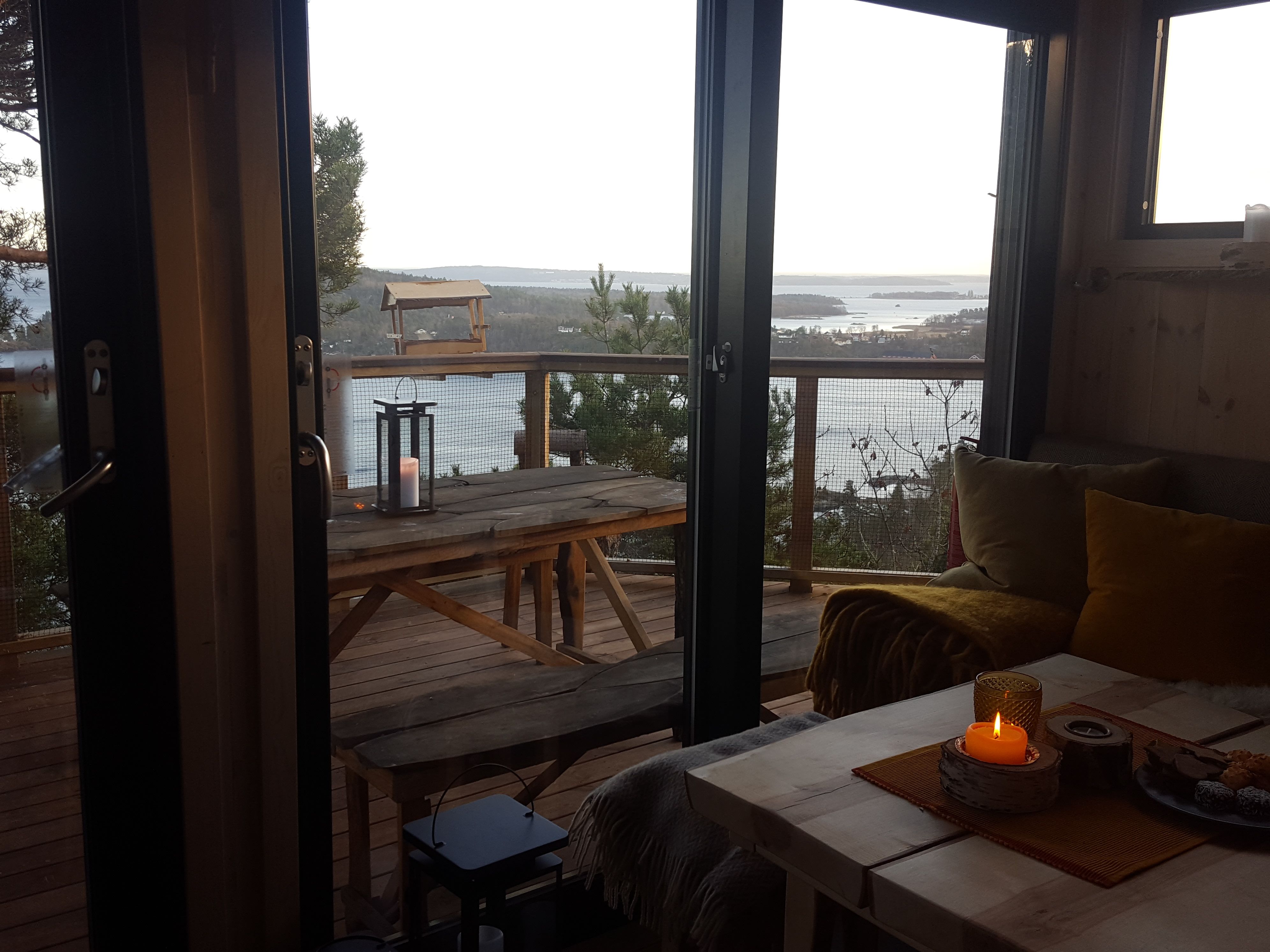 Living room in the evening, with a view out over nature and the water