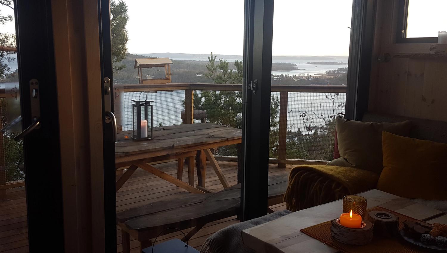 Living room in the evening, with a view out over nature and the water