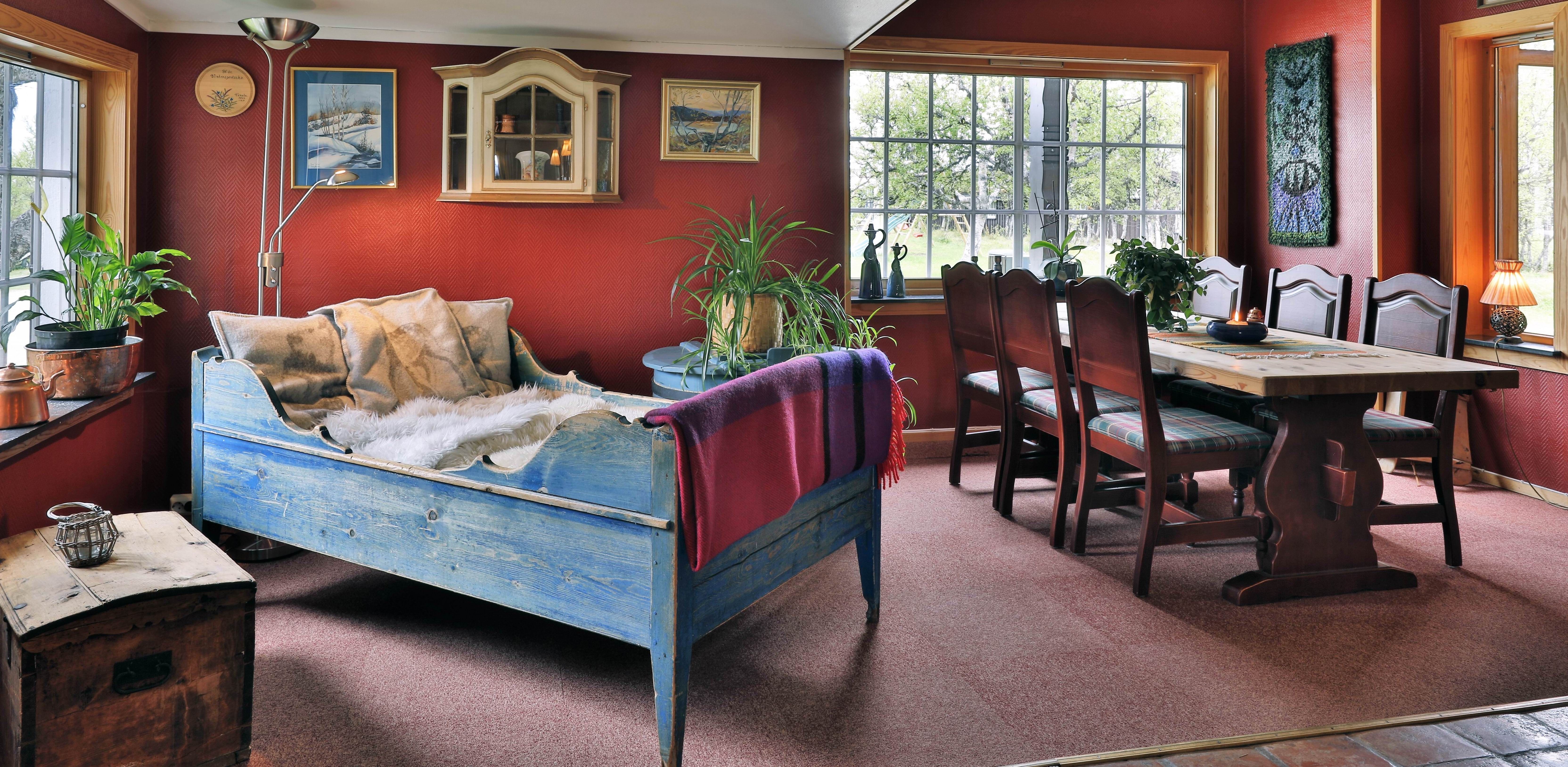 A cosy corner with an old style bed and dining table at Venabu Fjellhotell