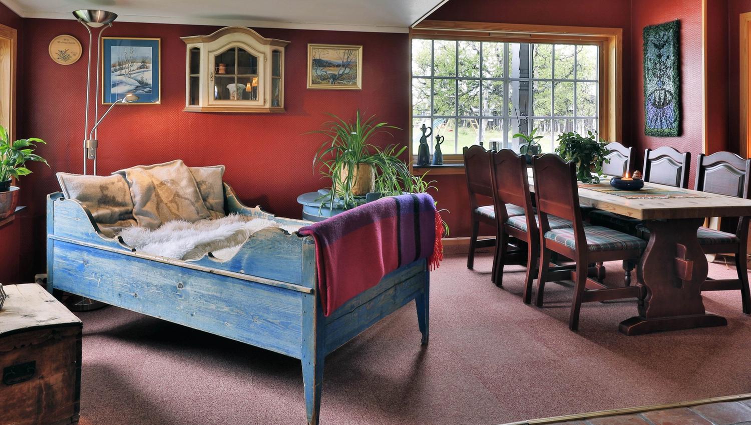 A cosy corner with an old style bed and dining table at Venabu Fjellhotell