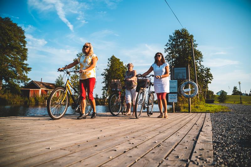 Three women walking with their bikes