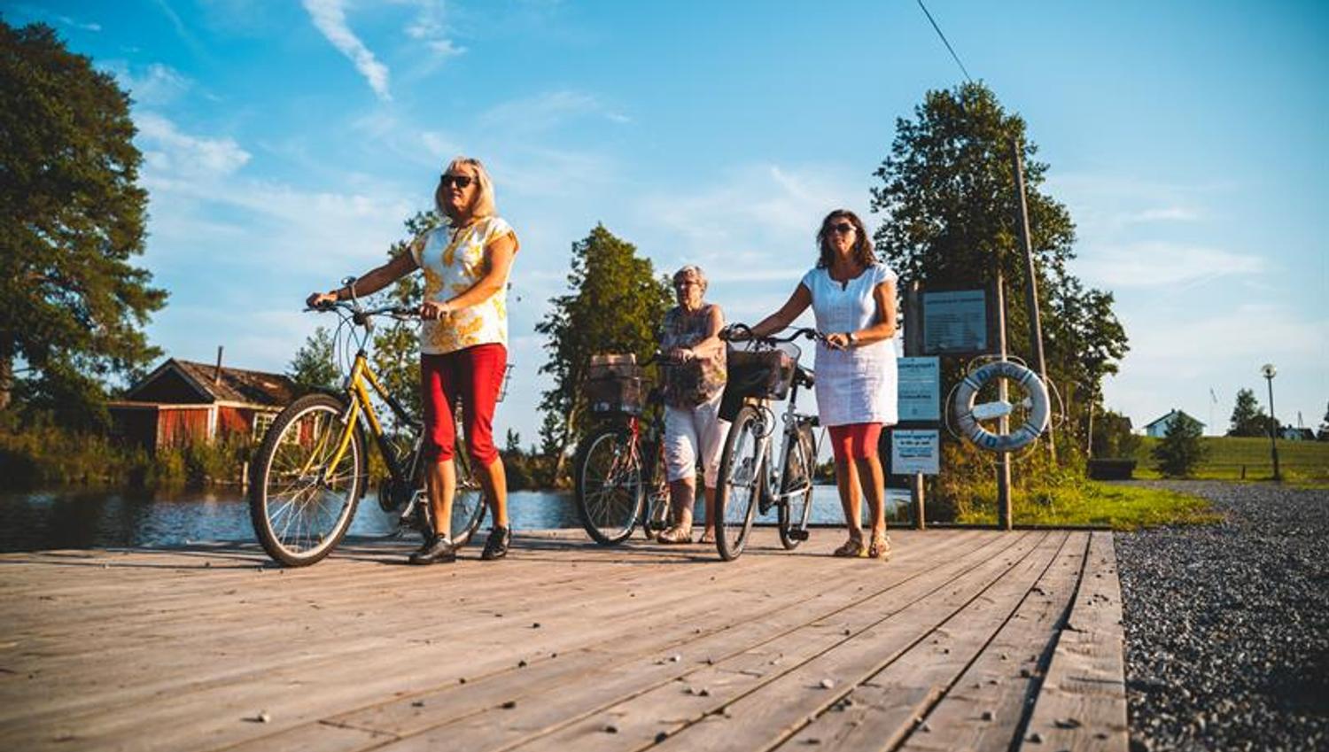 Three women walking with their bikes