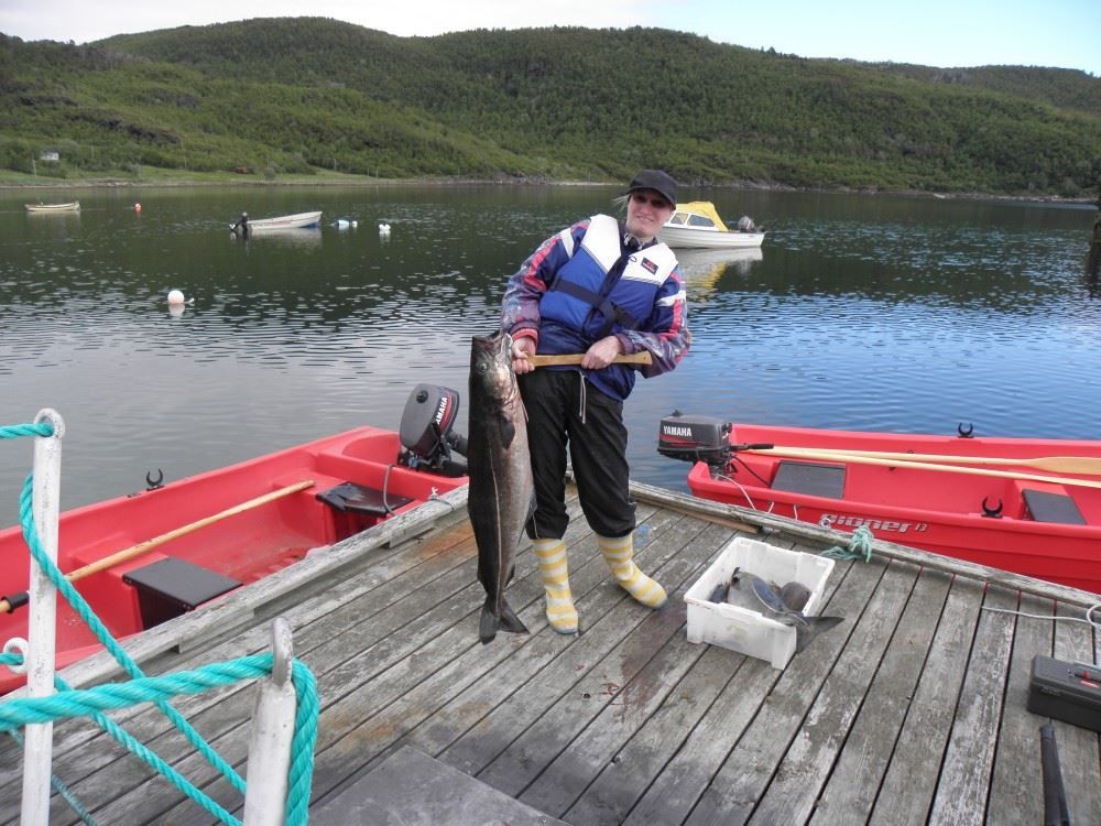 lady with proud fish catch on pier.