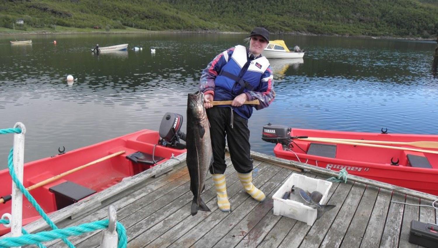 lady with proud fish catch on pier.
