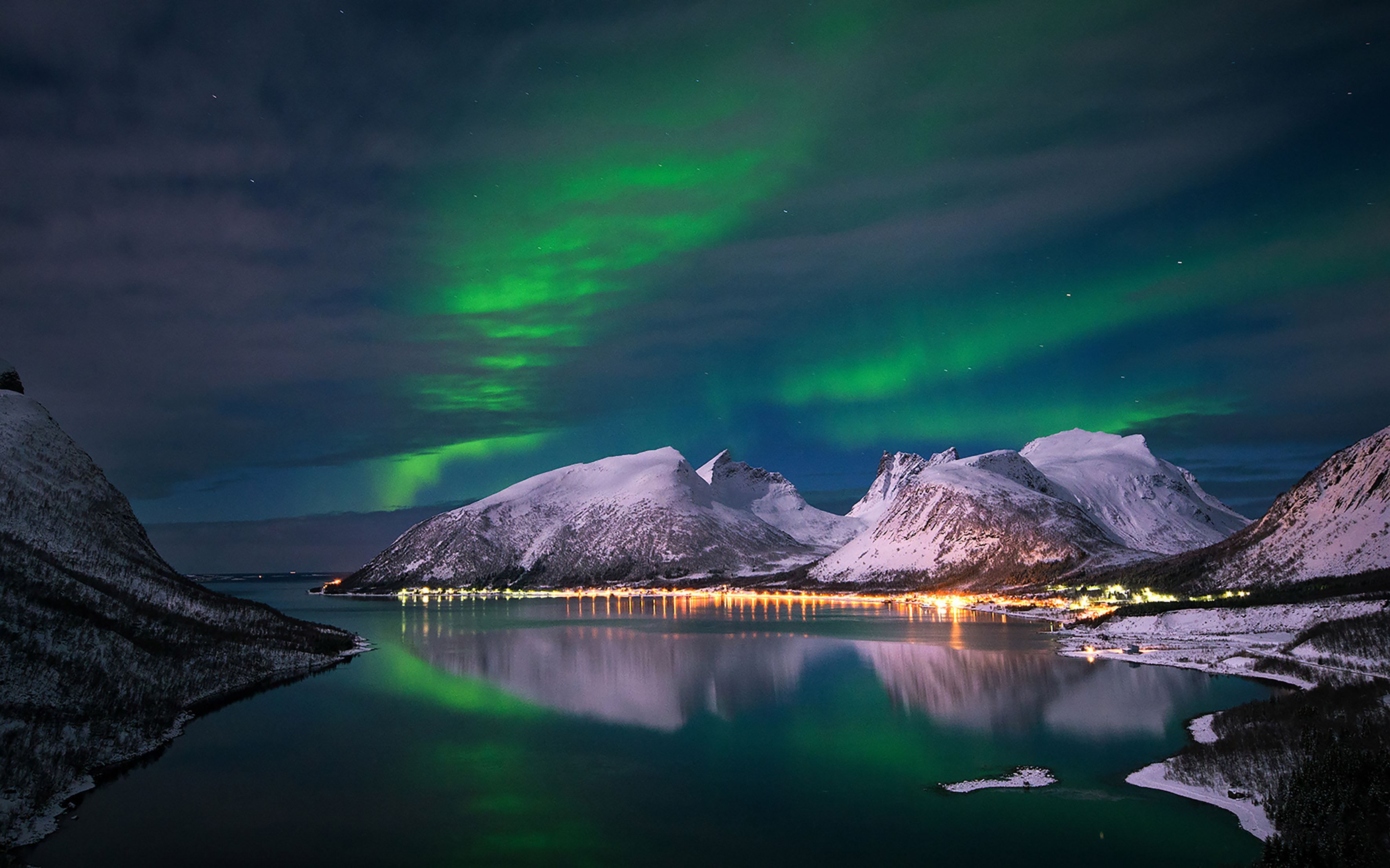 Northern Lights above snow-covered mountains on Senja.