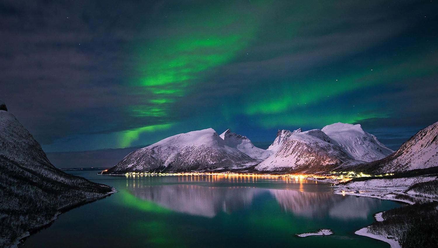 Northern Lights above snow-covered mountains on Senja.
