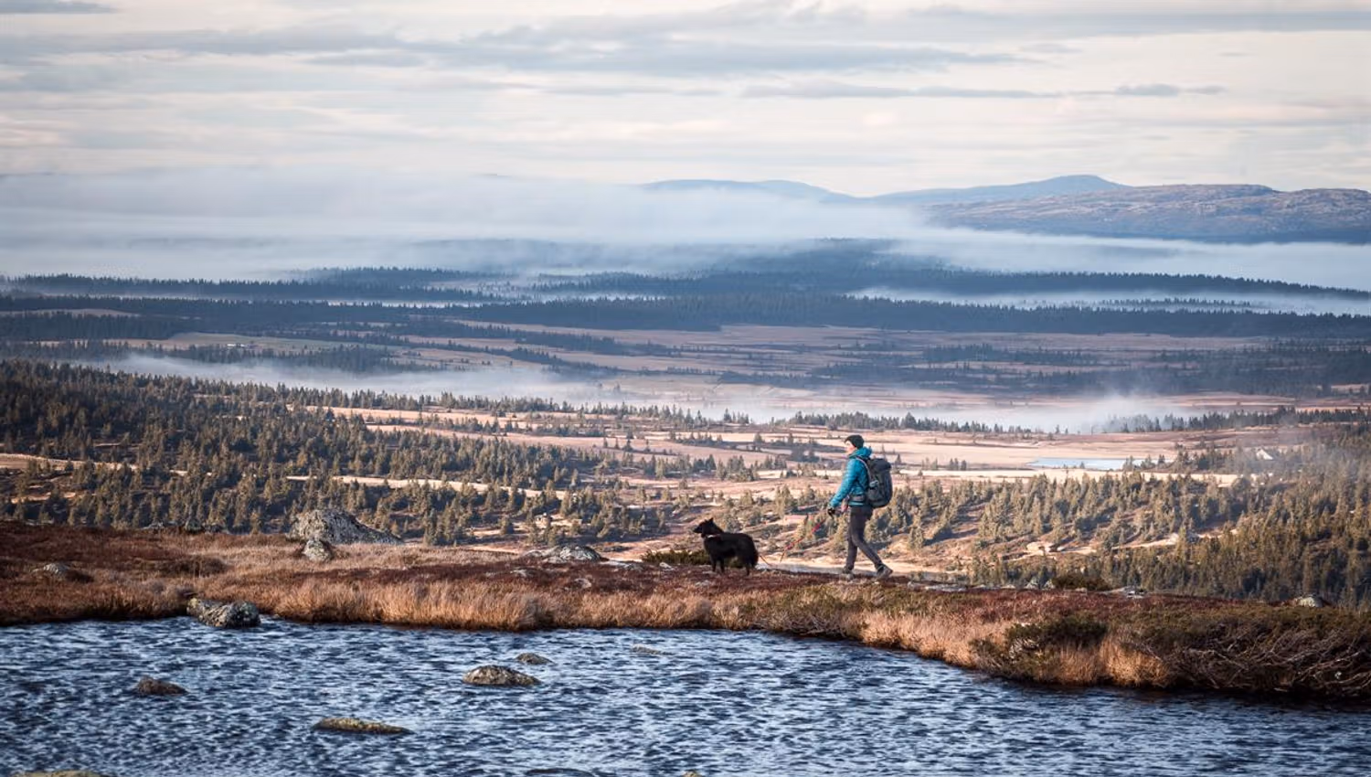 Person by water in a mountain landscape with views