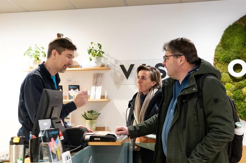 Employee assisting two customers at the tourist information office