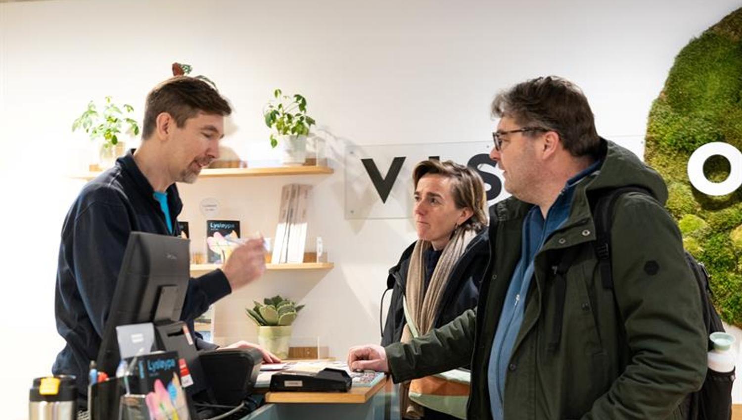 Employee assisting two customers at the tourist information office